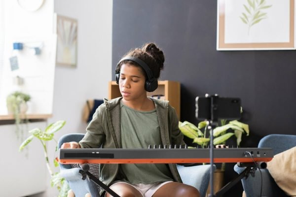 cute-preteen-biracial-schoolgirl-playing-piano-key-2022-01-19-00-15-27-utc.jpg