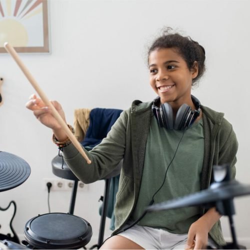 happy-cute-schoolgirl-with-drumsticks-hitting-drum-2021-12-16-00-28-52-utc.jpg